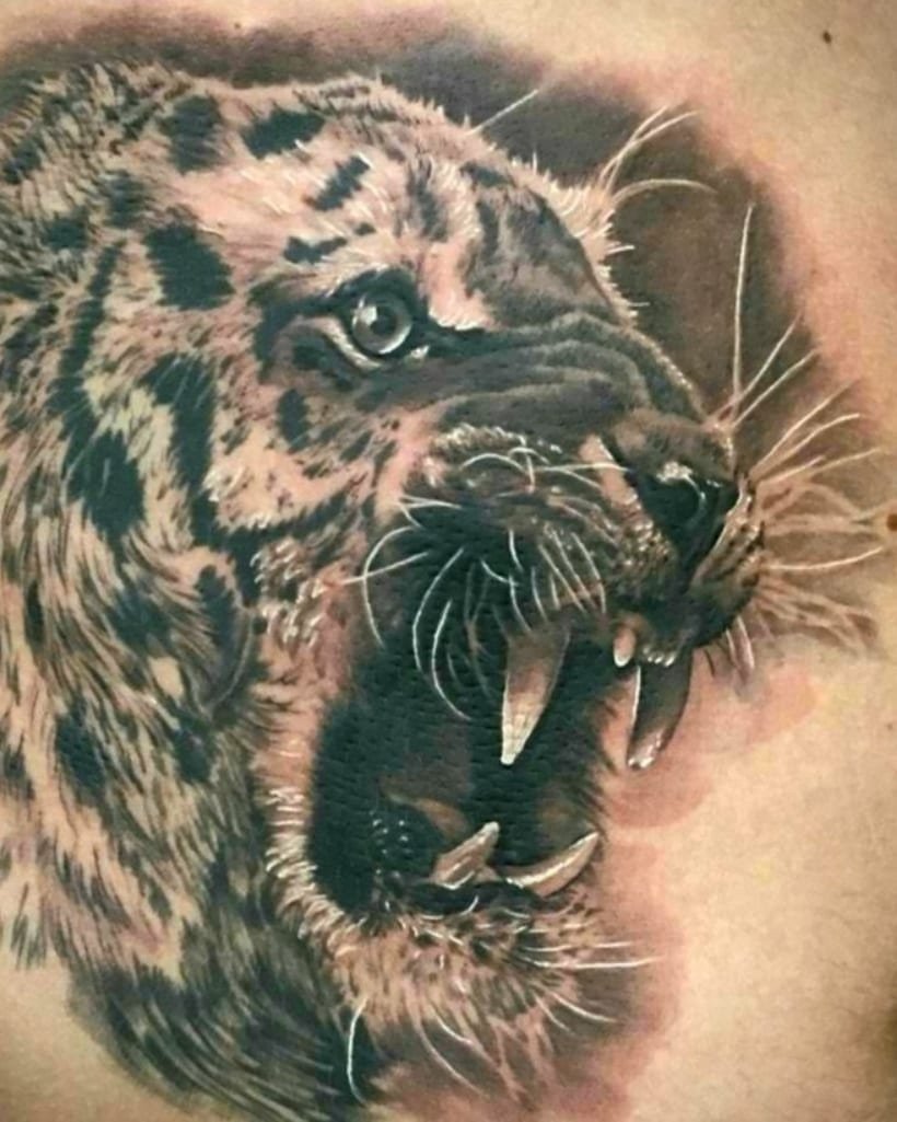 Black and grey realistic animal eyes close-up tattoo